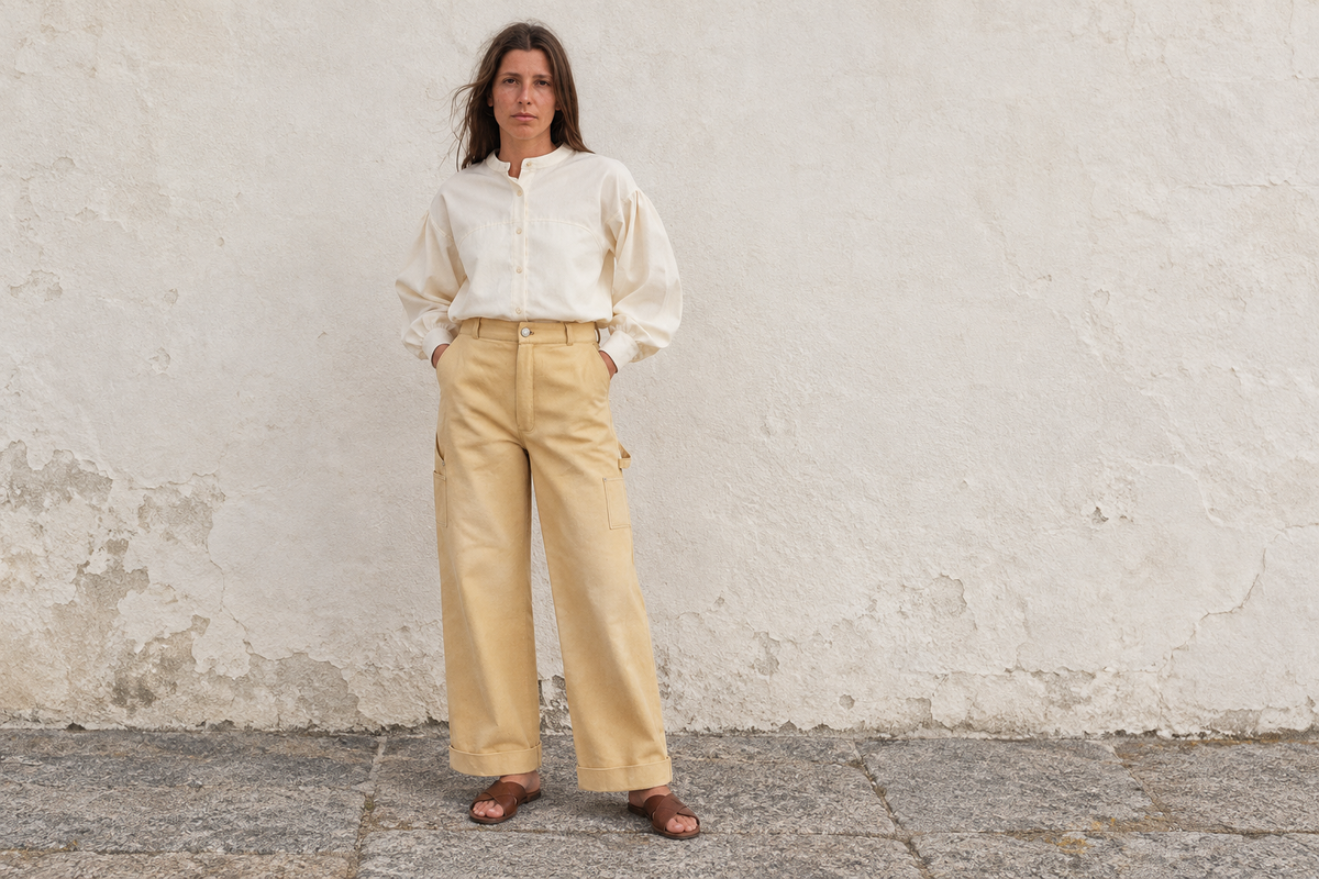 Blouse Wave Écru rentrée dans le pantalon large Longboard Sable, avec des sandales plates.